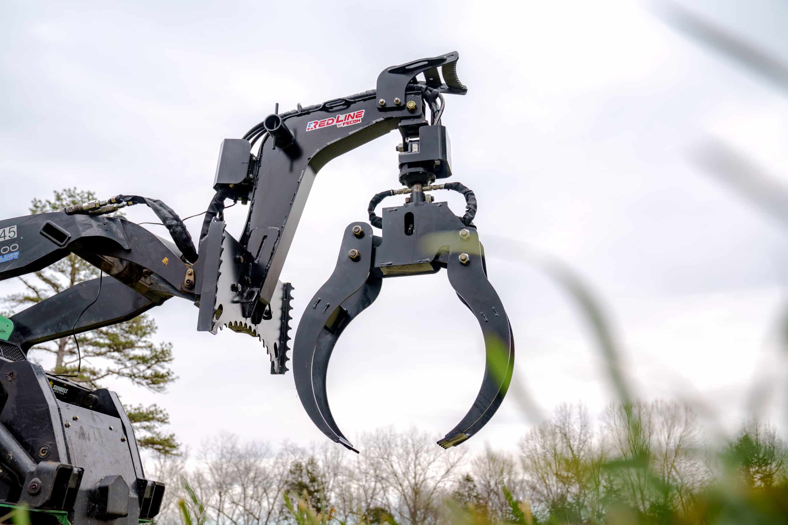 Mini skid steer log grapple with rope bollards and push bar on a compact loader