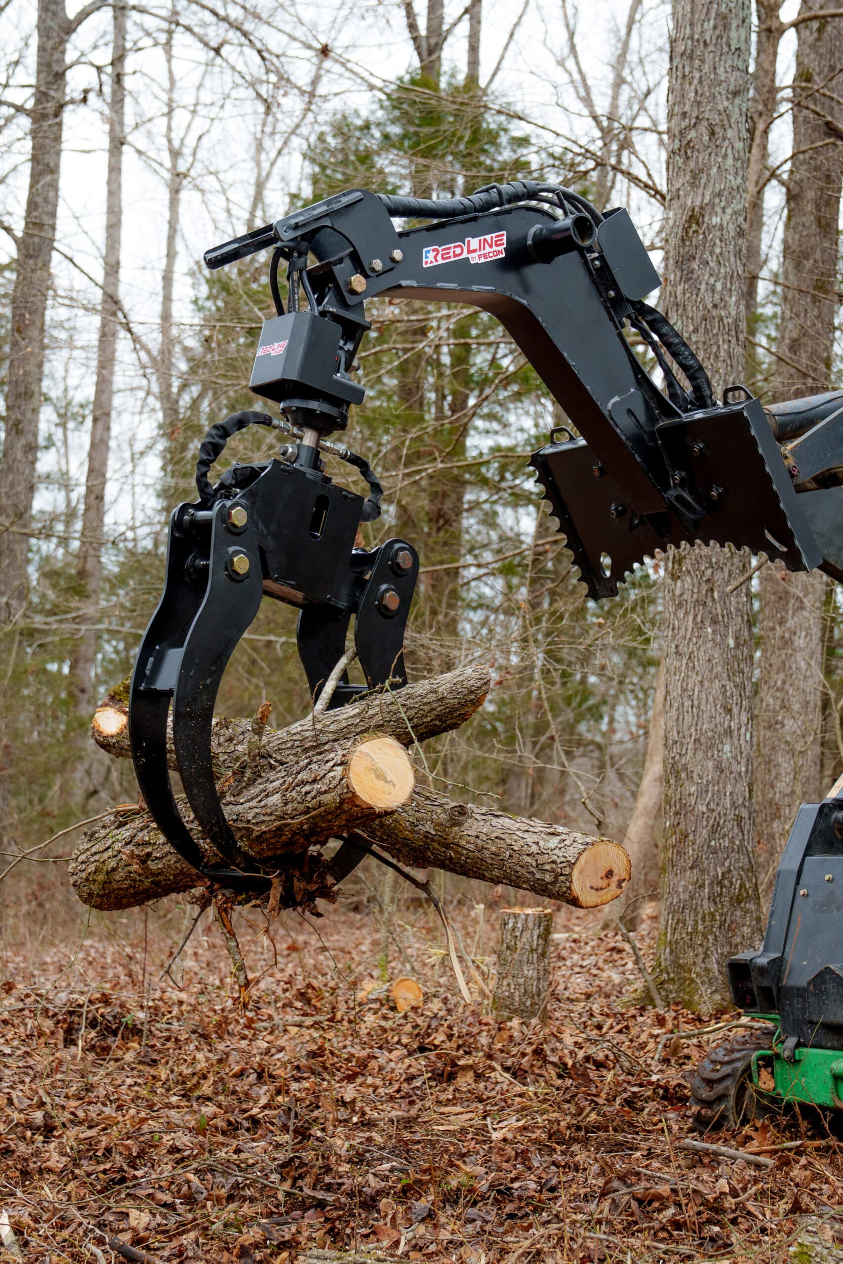 Fecon LG57 rotating log grapple turning a log upright on a mini skid steer